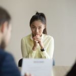 面接官の前で祈る女性
